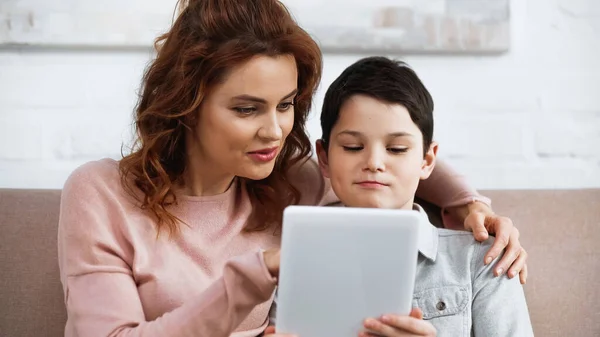 Mulher Sorridente Abraçando Filho Usando Tablet Digital Durante Educação Line — Fotografia de Stock