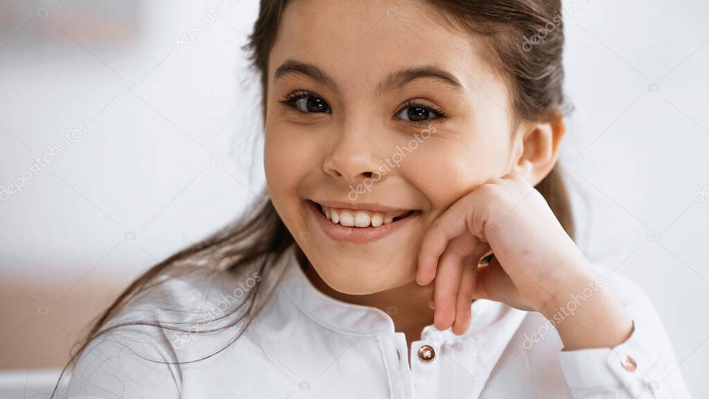 Positive preteen kid smiling at camera 