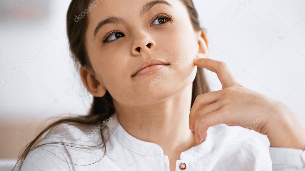 Pensive preteen girl looking away at home 