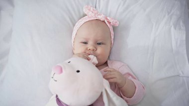 Saç bantlı, yumuşak oyuncaklı bebek manzarası 