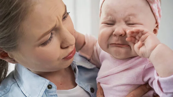 悲しい泣いてる赤ん坊を抱いてる母親 — ストック写真