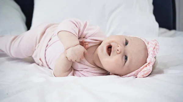 Χαρούμενο Κοριτσάκι Ξαπλωμένο Στο Κρεβάτι Στο Σπίτι — Φωτογραφία Αρχείου