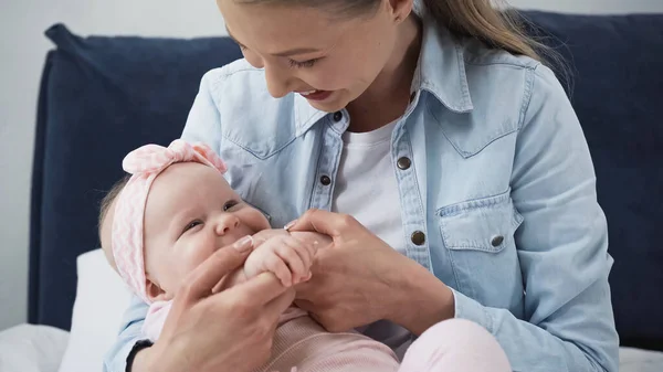 Pleased Mother Holding Hands Baby Daughter — Stock Photo, Image