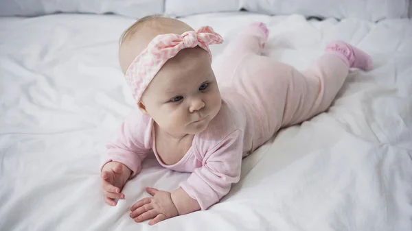 Mädchen Mit Stirnband Und Schleife Liegt Auf Bett — Stockfoto