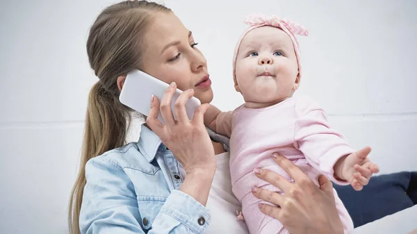 Mulher Falando Smartphone Enquanto Segurando Nos Braços Criança Filha — Fotografia de Stock