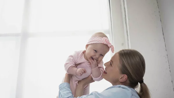 Sonriente Mujer Sosteniendo Brazos Infantil Hija Diadema — Foto de Stock