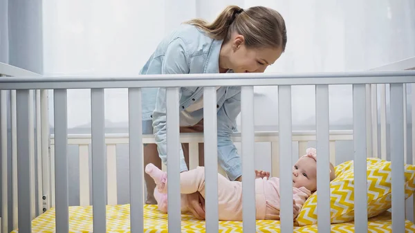 Mãe Feliz Colocando Filha Infantil Berço Bebê — Fotografia de Stock