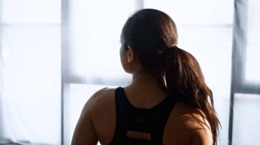 Kırpılmış bluzlu genç bir kadın spor salonunda gözlerini kaçırıyor. 