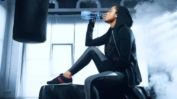 Sportswoman Hoodie Sitting Tire Drinking Water Sports Bottle — Stock Photo, Image