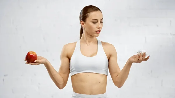 Sportvrouw Zoek Naar Marshmallow Terwijl Het Houden Van Appel — Stockfoto