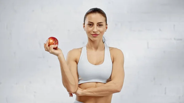 Sportswoman Sorrindo Segurando Maçã Orgânica — Fotografia de Stock