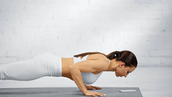 Zijaanzicht Van Sporter Doet Plank Buurt Van Smartphone Fitness Mat — Stockfoto