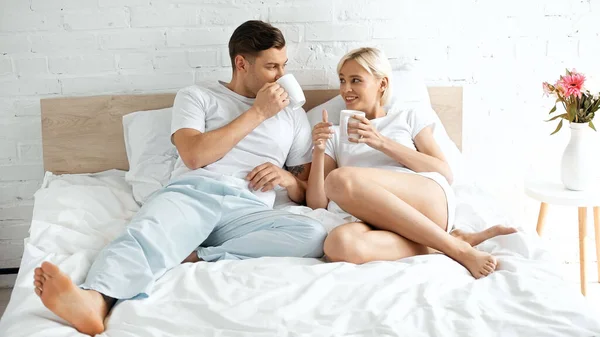 Smiling Young Woman Looking Boyfriend Drinking Coffee Bed — Stock Photo, Image