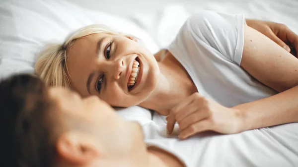 Cheerful Woman Laughing While Lying Bed Boyfriend Blurred Foreground — Stock Photo, Image