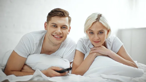 Feliz Casal Sorrindo Enquanto Assiste Filme Quarto — Fotografia de Stock