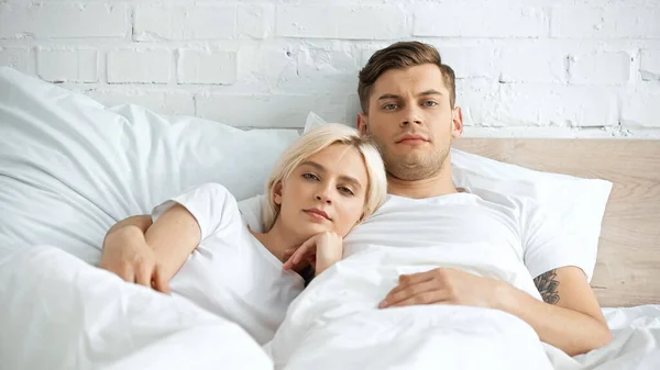 Dövmeli Adam Yatakta Sarışın Kız Arkadaşıyla Yatıyor — Stok fotoğraf