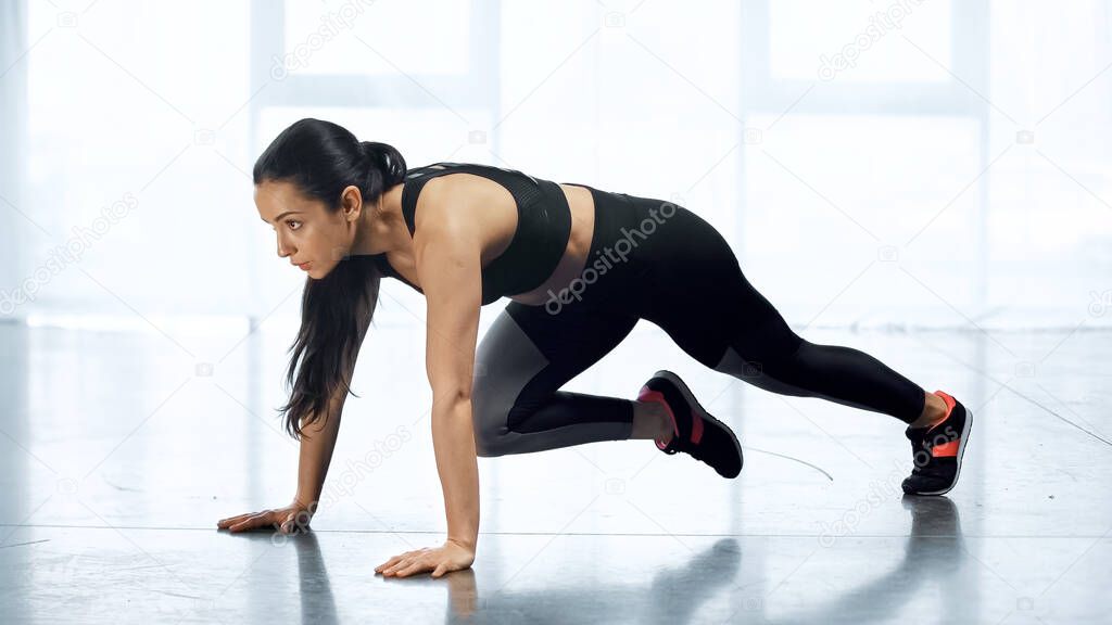 young woman in sportswear exercising in gym 