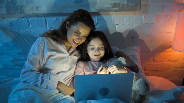 Zâmbind Femeie Fiică Folosind Laptop Pat Timpul Nopții — Fotografie, imagine de stoc