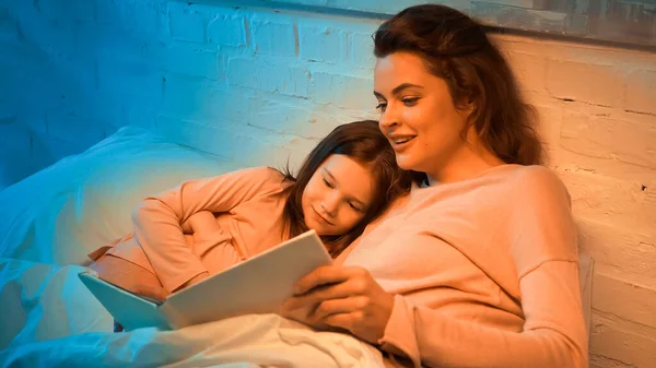 Sonriente Madre Leyendo Libro Cerca Hija Cama — Foto de Stock