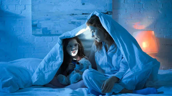 Мать Ребенок Держат Фонарик Одеялом Кровати Ночью — стоковое фото