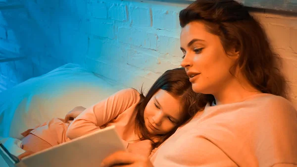 Niño Acostado Cerca Madre Leyendo Libro Borroso Dormitorio — Foto de Stock