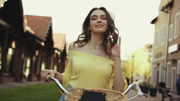 Feliz Joven Mujer Con Pelo Ondulado Sonriendo Mientras Monta Bicicleta — Foto de Stock