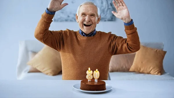 Anciano Emocionado Celebrando Cumpleaños Delante Torta Con Velas Encendidas Sala — Foto de Stock