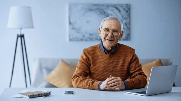 Feliz Anciano Sentado Con Las Manos Apretadas Mesa Con Ordenador — Foto de Stock