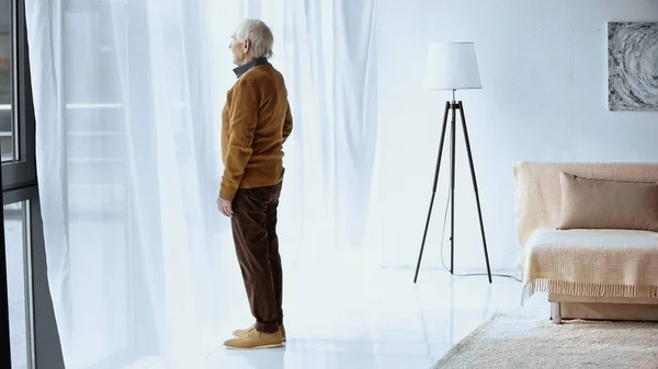 Profil Pohled Starší Muže Stojící Okna Moderním Obývacím Pokoji — Stock fotografie