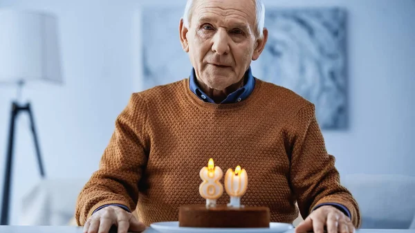 Eenzame Oudere Man Zittend Voor Verjaardagstaart Met Kaarsen Kijkend Naar — Stockfoto