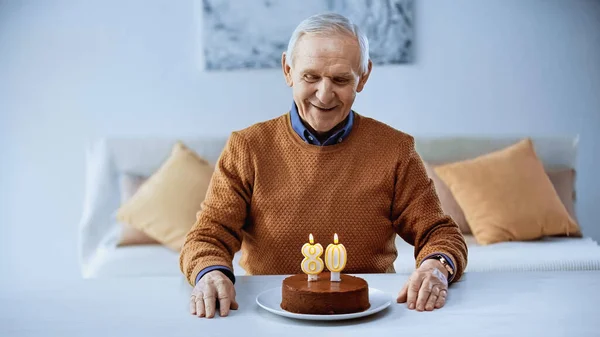 Feliz Anciano Celebrando Cumpleaños Delante Torta Con Velas Encendidas Sala — Foto de Stock