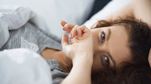 Young Curly Woman Covering Face Hand While Lying Bed Morning — Stock Photo, Image