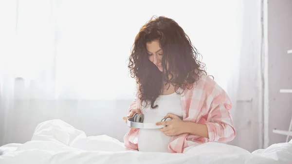 Mulher Grávida Feliz Segurando Fones Ouvido Sem Fio Perto Barriga — Fotografia de Stock