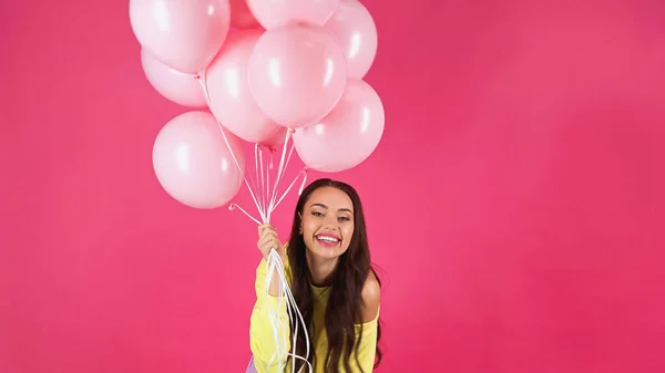 Joyful Young Adult Woman Yellow Sweatshirt Holding Balloons Isolated Pink — Φωτογραφία Αρχείου