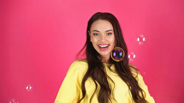 Positive Young Adult Woman Yellow Blouse Soap Bubbles Pink Background — Stockfoto