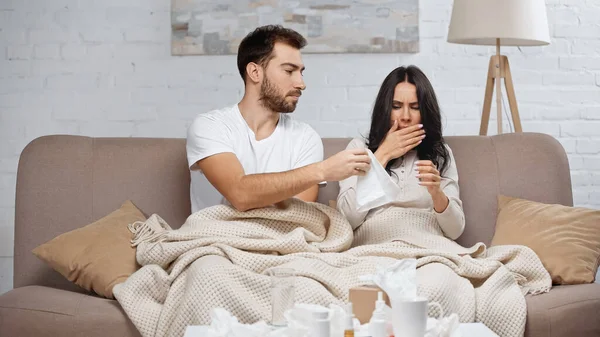 Caring Man Giving Tissue Sick Woman Sneezing Living Room — Fotografia de Stock