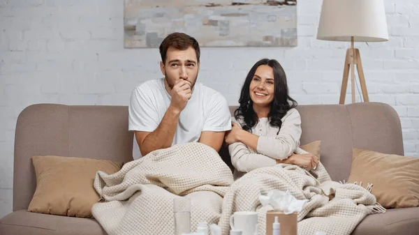 Brunette Woman Smiling Sick Boyfriend Coughing Living Room — Fotografia de Stock