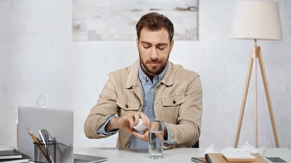 Алергічний Бізнесмен Тримає Пляшку Таблетками Біля Ноутбука Столі — стокове фото