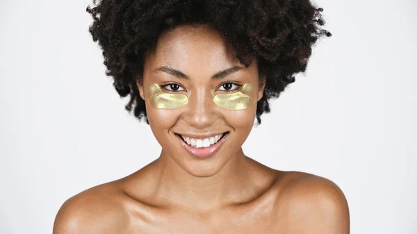 Glimlachende Afro Amerikaanse Vrouw Met Gouden Ooglapjes Geïsoleerd Grijs — Stockfoto