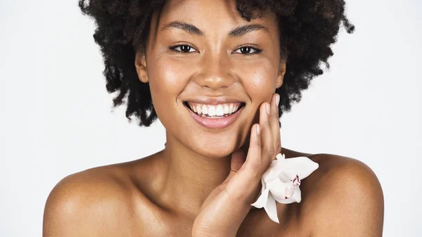 Mulher Afro Americana Positiva Com Orquídea Tocando Rosto Isolado Cinza — Fotografia de Stock