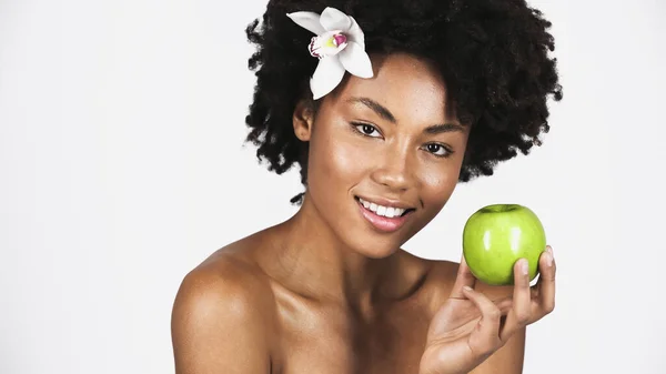 Mujer Afroamericana Sonriente Con Orquídea Pelo Sosteniendo Manzana Verde Aislada — Foto de Stock