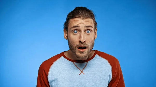 Homme choqué et barbu regardant caméra sur bleu — Photo de stock