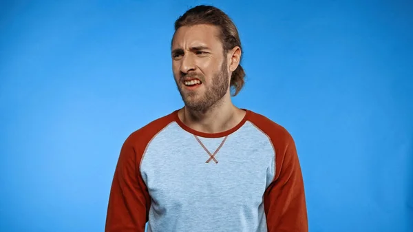 Bearded man feeling disgusting smell on blue — Stock Photo