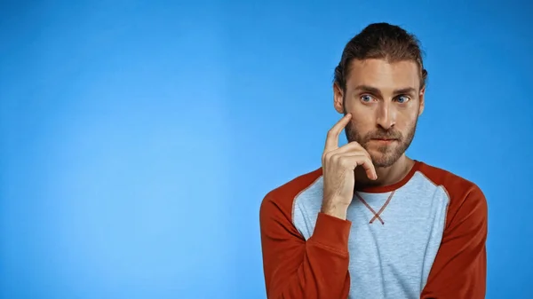 Thoughtful man looking away on blue background — Stock Photo