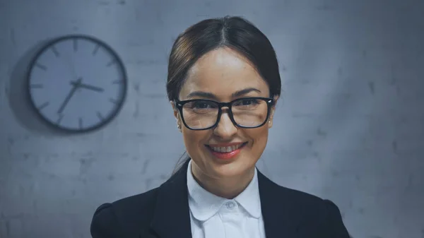 Agent d'assurance dans les lunettes souriant à la caméra dans le bureau — Photo de stock