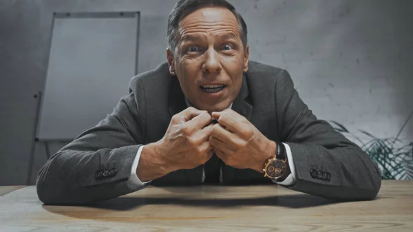 Irritated insurance agent looking at camera at table — Stock Photo