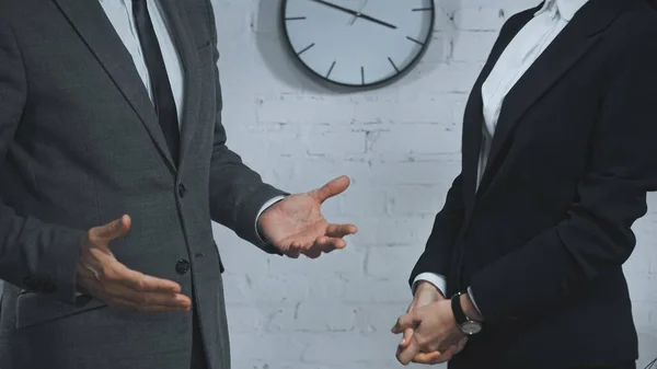 Vue recadrée de l'agent d'assurance pointant avec les mains près d'un collègue au bureau — Photo de stock