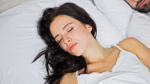 Jeune femme brune dormant près du petit ami à la maison — Photo de stock