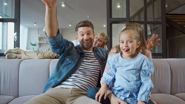 Alegre familia pasar tiempo en el sofá en casa - foto de stock