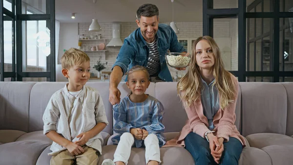 Familie sitzt bei Vater mit Popcorn auf Couch — Stockfoto